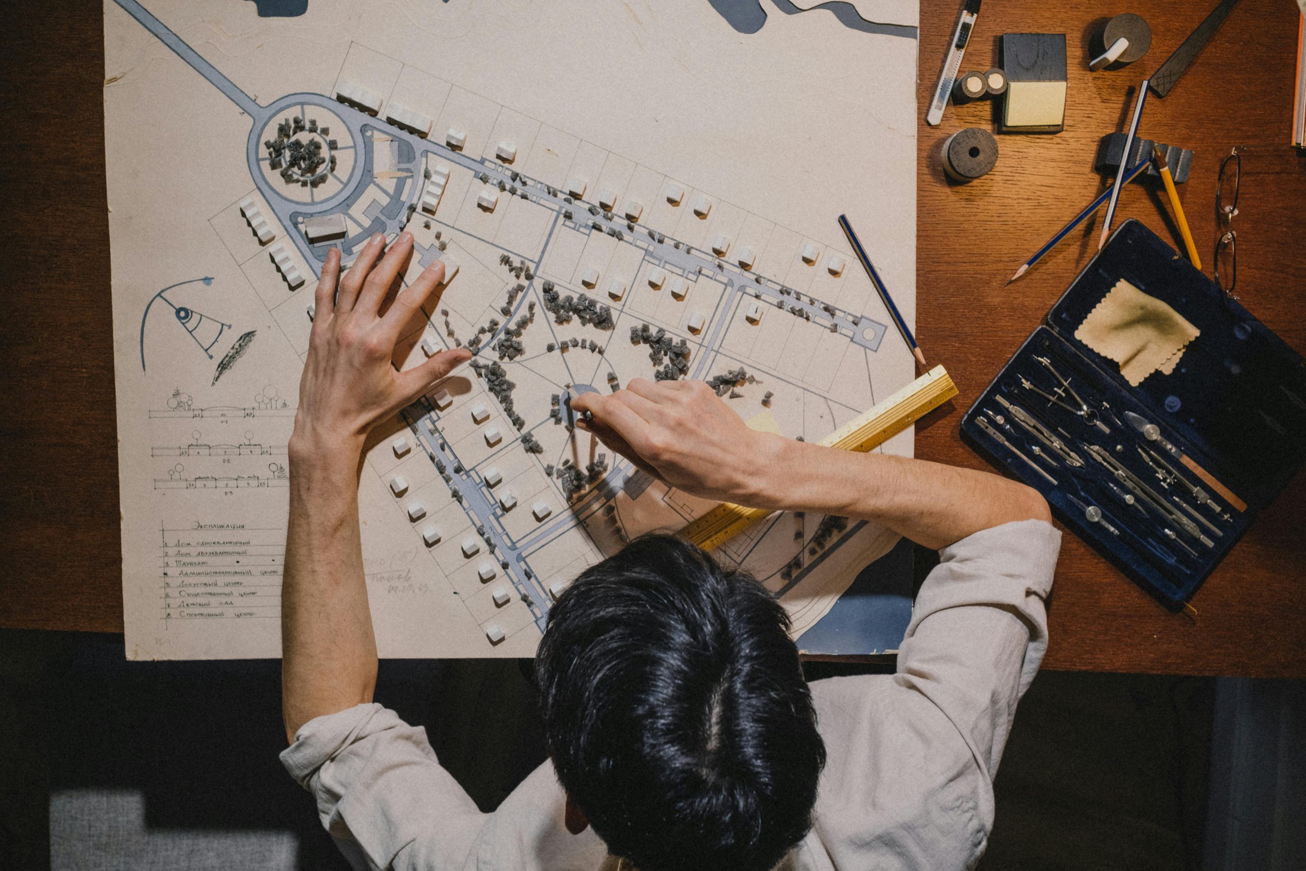 Top view of an architect working on a design project with precision tools.